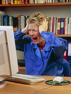 Stressed woman shouting at an office computer Stressed woman shouting at an office computer