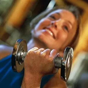 Images Dated 16th February 1998: Woman does arm curling exercise with a dumb-bell