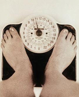 Womans feet on a set of weighing scales Womans feet on a set of weighing scales
