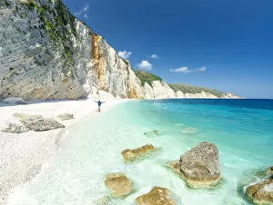 Aerial view of cheerful man with arms outstretched admiring the crystal sea at Fteri Beach, Kefalonia, Ionian Islands