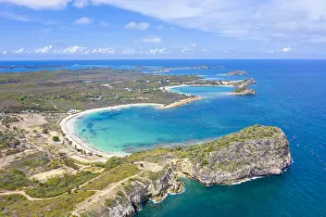 Aerial view by drone of cliffs surrounding Half Moon Bay washed by Caribbean Sea, Antigua Aerial view by drone of cliffs surrounding Half Moon Bay washed by Caribbean Sea, Antigua