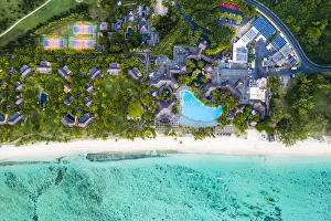 Aerial view by drone of luxury tourist resort on palm-fringed beach facing the tropical Aerial view by drone of luxury tourist resort on palm-fringed beach facing the tropical