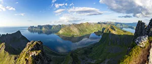 Aerial view of Husfjellet mountain and Devil's Teeth peaks reflected in the fjord at Aerial view of Husfjellet mountain and Devil's Teeth peaks reflected in the fjord at