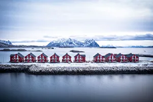 Aerial view of red rorbu cabins in a row amidst the cold sea in winter, Svolvaer, Nordland county, Lofoten Islands Aerial view of red rorbu cabins in a row amidst the cold sea in winter, Svolvaer, Nordland county, Lofoten Islands