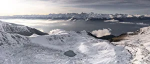 Aerial view of snowcapped Orobie Alps and Piani di Rhon emerging from autumn fog at dawn Aerial view of snowcapped Orobie Alps and Piani di Rhon emerging from autumn fog at dawn