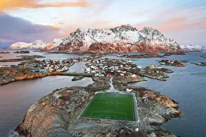 Aerial view of soccer stadium and Henningsvaer village during winter dawn, Nordland county, Lofoten Islands, Norway Aerial view of soccer stadium and Henningsvaer village during winter dawn, Nordland county, Lofoten Islands, Norway