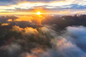 Aerial view of sun rays at sunset lighting up the clouds over Romsdalen valley, Andalsnes Aerial view of sun rays at sunset lighting up the clouds over Romsdalen valley, Andalsnes