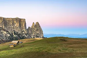 Autumn sunrise over Sciliar peaks and wood huts at Alpe di Siusi (Seiser Alm), Dolomites Autumn sunrise over Sciliar peaks and wood huts at Alpe di Siusi (Seiser Alm), Dolomites