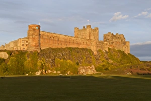 Bamburgh Castle and Cricket Green in evening sunshine, Bamburgh, Northumberland, England Bamburgh Castle and Cricket Green in evening sunshine, Bamburgh, Northumberland, England