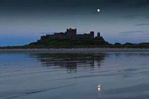 Norman Gallery: Bamburgh Castle under a full moon at dusk in summer, Bamburgh, Northumberland, England