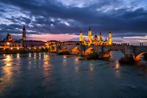 Basilica del Pilar Cathedral and Salvador Cathedral with stone bridge crossing Ebro River at night, Zaragoza, Aragon Basilica del Pilar Cathedral and Salvador Cathedral with stone bridge crossing Ebro River at night, Zaragoza, Aragon