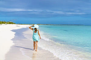Beautiful woman walking on idyllic beach washed by Caribbean Sea, Barbuda, Antigua and Barbuda, West Indies, Caribbean
