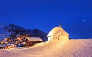 Blue dusk on the alpine village and church covered with snow, Bettmeralp Blue dusk on the alpine village and church covered with snow, Bettmeralp