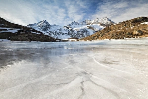 Blue sky and clouds on frozen Lej Nair surrounded by snowy peaks, Bernina Pass, Canton Blue sky and clouds on frozen Lej Nair surrounded by snowy peaks, Bernina Pass, Canton