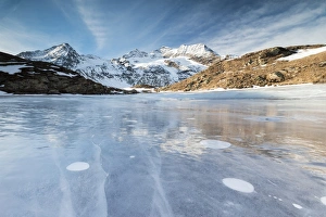 Blue sky on the frozen Lej Nair surrounded by snowy peaks, Bernina Pass, Canton of Graubunden Blue sky on the frozen Lej Nair surrounded by snowy peaks, Bernina Pass, Canton of Graubunden