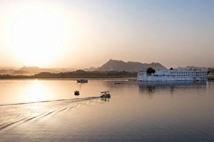 Boat going out to Lake Palace Hotel at dusk, the hotel is situated in the middle of Lake Boat going out to Lake Palace Hotel at dusk, the hotel is situated in the middle of Lake
