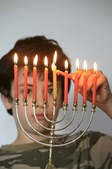 Images Dated 28th March 2007: Boy lighting Hanukkah candles