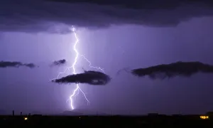 A bright lightning bolt passing through a cloud and striking in the Gila Bend Mountains A bright lightning bolt passing through a cloud and striking in the Gila Bend Mountains