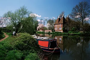 Brightly painted barge and oast houses on the River Medway, Yalding, near Maidstone Brightly painted barge and oast houses on the River Medway, Yalding, near Maidstone