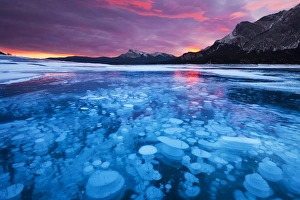 Bubbles and Cracks in the Ice with Kista Peak in the Background at Sunrise, Abraham Lake Bubbles and Cracks in the Ice with Kista Peak in the Background at Sunrise, Abraham Lake