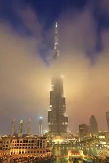 Images Dated 14th March 2011: Burj Khalifa illuminates the clouds and surrounding skyline at night, Downtown