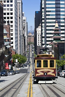 Cable car crossing California Street with Bay Bridge backdrop in San Francisco Cable car crossing California Street with Bay Bridge backdrop in San Francisco