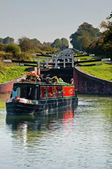 A canal boat leaving the famous series of locks at Caen Hill on the Kennet and Avon Canal, Wiltshire, England