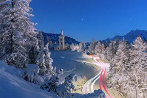 Places Of Worship Gallery: Car trails lights on snowy mountain road leading to Chiesa Bianca under the stars, Maloja, Engadine