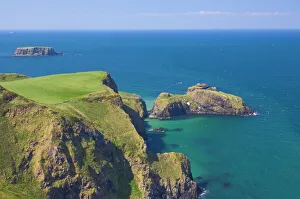 Carrick-a-rede rope bridge to Carrick Island, Larrybane Bay, with Sheep Island in the background Carrick-a-rede rope bridge to Carrick Island, Larrybane Bay, with Sheep Island in the background
