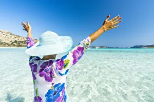 Cheerful woman with arms raised sunbathing in the clear sea, Crete, Greek Islands, Greece Cheerful woman with arms raised sunbathing in the clear sea, Crete, Greek Islands, Greece