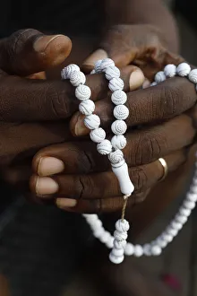 Close-up of hands of African Muslim man praying with Islamic prayer beads (tasbih), Togo Close-up of hands of African Muslim man praying with Islamic prayer beads (tasbih), Togo