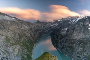 Clouds at sunset over the pristine lake Limmernsee and mountains, aerial view Clouds at sunset over the pristine lake Limmernsee and mountains, aerial view