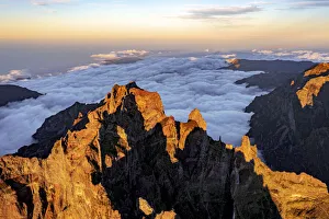 Clouds surrounding the rocky peak of Pico das Torres lit by sunset, Madeira island Clouds surrounding the rocky peak of Pico das Torres lit by sunset, Madeira island