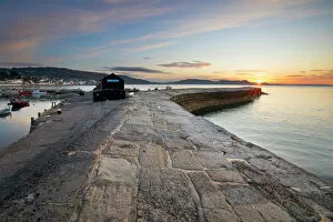 Lens Flare Collection: The Cobb with the cliffs of Jurassic Coast at sunrise, Lyme Regis, Dorset, England