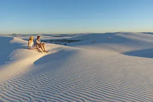 A couple enjoys White Sands National Park at sunset, New Mexico, United States of America A couple enjoys White Sands National Park at sunset, New Mexico, United States of America