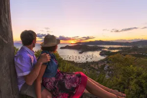 Couple look to the English Harbor from Shirley Heights at sunset, Antigua, Antigua and Barbuda Couple look to the English Harbor from Shirley Heights at sunset, Antigua, Antigua and Barbuda
