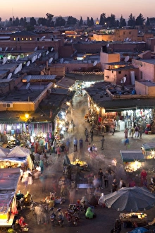 Crowds of locals and tourists walking among the shops and stalls in the Djemaa el Fna at Crowds of locals and tourists walking among the shops and stalls in the Djemaa el Fna at