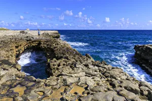 Devils Bridge, limestone rock formation and arch, tourist takes selfie, Antigua Devils Bridge, limestone rock formation and arch, tourist takes selfie, Antigua