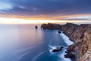 Dramatic sky at dawn on cliffs washed by ocean from Ponta Do Rosto viewpoint Dramatic sky at dawn on cliffs washed by ocean from Ponta Do Rosto viewpoint