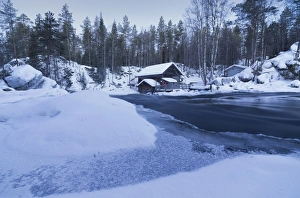 Dusk frames the frozen water in the snowy woods and a wooden hut, Juuma, Myllykoski Dusk frames the frozen water in the snowy woods and a wooden hut, Juuma, Myllykoski