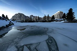 Dusk lights over the frozen lake Limides with Lagazuoi and Tofana di Rozes on background Dusk lights over the frozen lake Limides with Lagazuoi and Tofana di Rozes on background