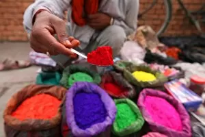 Offering Collection: A dye trader offers his brightly coloured wares in a roadside stall in Kathmandu