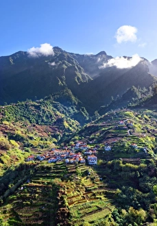 Elevated view of village and tree covered hills and mountains near Ponta Delgada Elevated view of village and tree covered hills and mountains near Ponta Delgada