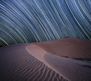 Equatorial star trail above sand dunes in the Rub al Khali desert, Oman, Middle East Equatorial star trail above sand dunes in the Rub al Khali desert, Oman, Middle East