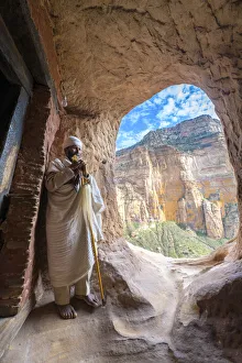 Places Of Worship Gallery: Ethiopian Orthodox priest holding the hand cross at entrance of Abuna Yemata Guh church