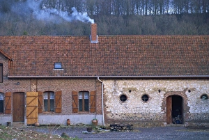 Exterior of a single storey house in the countryside, with smoking chimney Exterior of a single storey house in the countryside, with smoking chimney