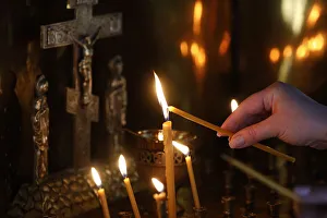 Faithful lighting a candle in Saint Teaodor Tiron (Ciuflea) Cathedral and Monastery Faithful lighting a candle in Saint Teaodor Tiron (Ciuflea) Cathedral and Monastery