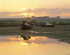 Fishing boat at sunset on the Aln estuary at low tide, Alnmouth, Northumberland Fishing boat at sunset on the Aln estuary at low tide, Alnmouth, Northumberland
