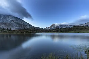 Fletschhorn mountain peak reflected in the pristine water of Hopschusee lake at dusk Fletschhorn mountain peak reflected in the pristine water of Hopschusee lake at dusk