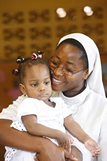 Franciscan sister holding an orphan at nursery and kindergarten run by Catholic nuns Franciscan sister holding an orphan at nursery and kindergarten run by Catholic nuns